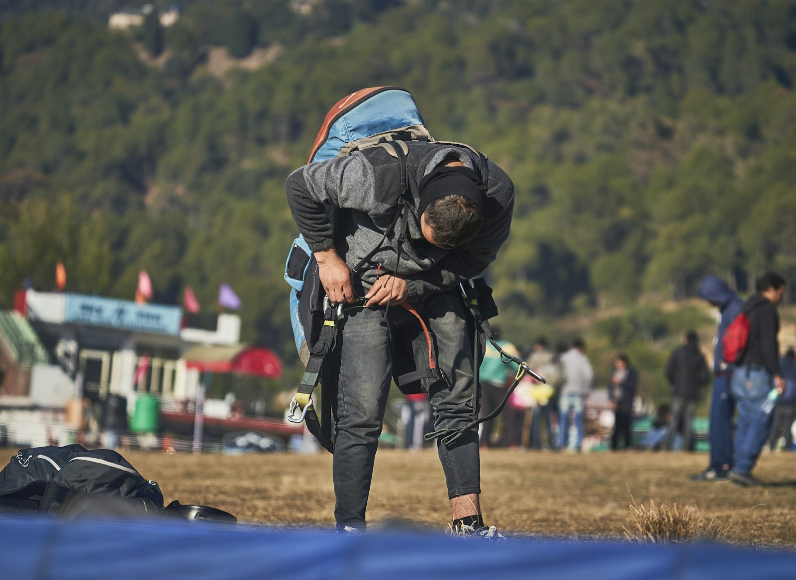 A backpacker walking across a green meadow